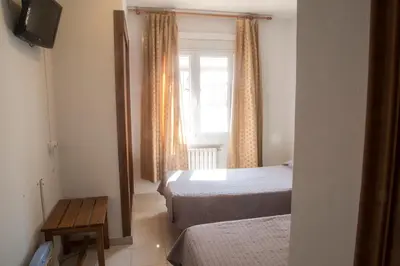 a hotel room with two beds and a window at Turó de L´Home in Santa María de Palautordera