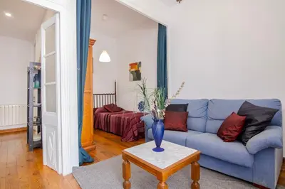 a living room with a blue couch and a table at Pedrera - Gràcia in Barcelona