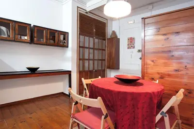 a dining room with a red table and chairs at Pedrera - Gràcia in Barcelona