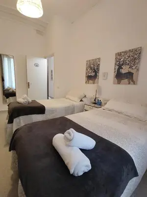 a hotel room with two beds with towels on them at Hostal Dragonflybcn in Barcelona