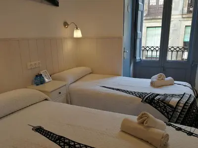 a room with two beds with towels on them at Hostal Dragonflybcn in Barcelona