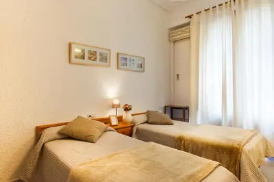 a hotel room with two beds and a window at Hostal Dragonflybcn in Barcelona