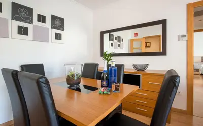 a kitchen with a refrigerator and a table at BONITO APARTAMENTO in Sitges