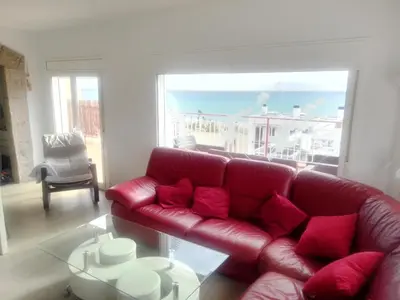 a red couch with red pillows in a living room at terraza al mar in Pineda de Mar