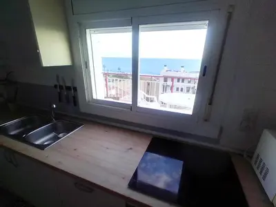 a kitchen with a sink and a window with a view at terraza al mar in Pineda de Mar