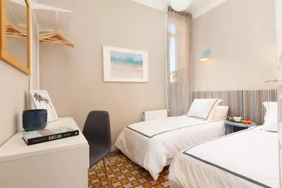 a room with two beds and a desk and a window at My Address on the Beach and Sun in Barcelona