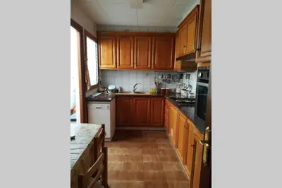 a kitchen with wooden cabinets and a counter top at Calella Playa in Calella