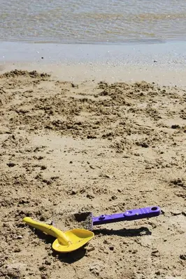 two beach items are laying on the sand on the beach at Camping La Rueda in Cubelles