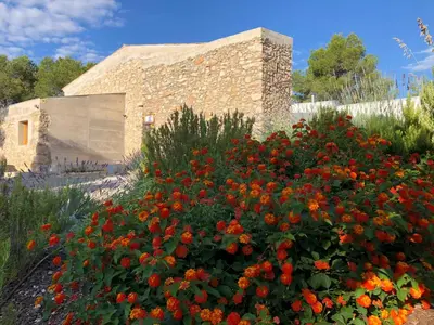 a garden with flowers in front of a building at Villa Can Tomeu Capdet in Sant Pere de Ribes