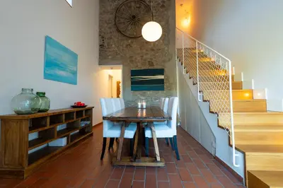 a dining room with a table and chairs and stairs at Villa Can Tomeu Capdet in Sant Pere de Ribes