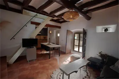 a living room with a table and a dining room at Cal Mestre Casa Rural in Avinyonet