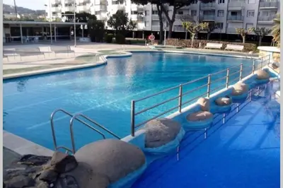 a large blue swimming pool with rocks in it at Residencial Costamar next Bcn, 50m beach with swimming pool in Cabrera de Mar