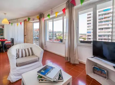 a living room with a white chair and a television at Can Mabi, 30' Bcn next beach in Vilassar de Mar