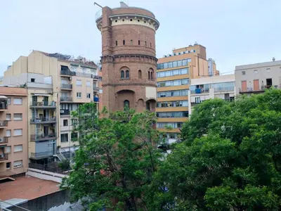 a tall brick tower in the middle of buildings at Fabrizzio's Petit in Barcelona