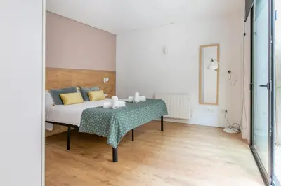 a bedroom with a bed with a table and a mirror at Chic and Modern Apartments in Gracia in Barcelona