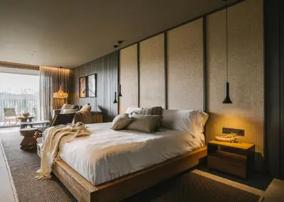 a bedroom with a large bed and a living room at Les Cabanes de l'Oller del Mas in Manresa