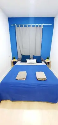a blue bed with two towels on top of it at Hostal Urban Basic in Hospitalet de Llobregat