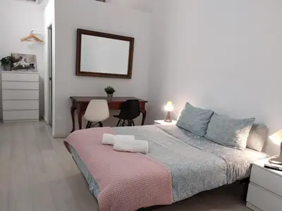 a bedroom with a large bed and a table at Hostal Urban Basic in Hospitalet de Llobregat