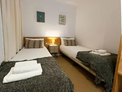 two beds in a small room with a night stand at Stay U-nique Apartments Borbó in Barcelona