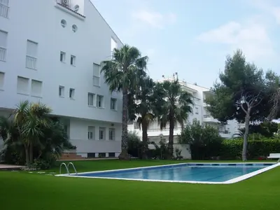 a swimming pool in front of a building at Apartamentos Sunway Talaia in Sitges