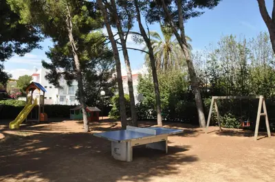 a playground with a table and a swing set at Apartamentos Sunway Talaia in Sitges