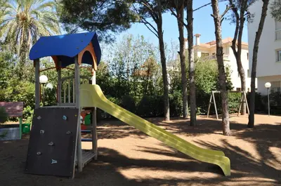 a playground with a slide in a park at Apartamentos Sunway Talaia in Sitges