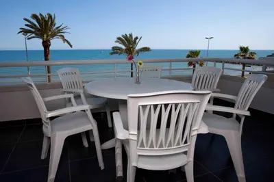 a white table and chairs on a balcony with the ocean at Apartamentos Sunway Talaia in Sitges