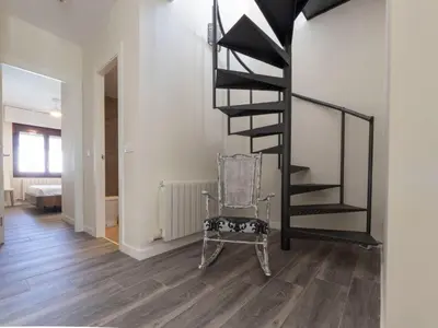 a black spiral staircase in a room with a chair at Holiday Home Aeris by Interhome in Cunit