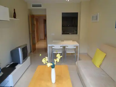 a living room with a vase of flowers on a table at Apartamentos Sitges in Sitges