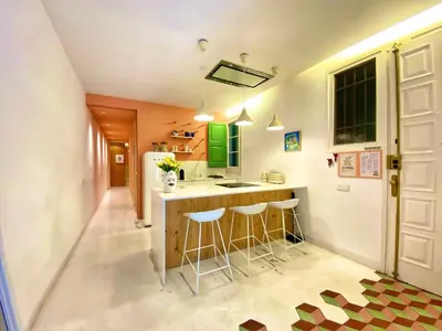 a kitchen with a counter and stools in it at Tyche apartment in Barcelona