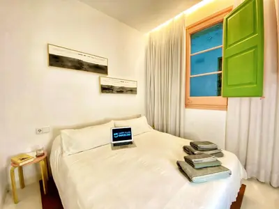 a bedroom with a bed with a laptop on it at Tyche apartment in Barcelona