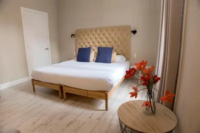 a bedroom with a bed with blue pillows and a table at Cami Gallery Barcelona in Barcelona
