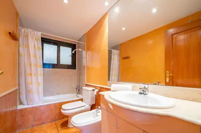 a bathroom with a sink and a toilet and a mirror at HomeHolidaysRentals Adara in Pineda de Mar