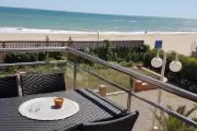 a table and chairs on a balcony overlooking the beach at Lovely Sea view Apartment in Gava in Gavà