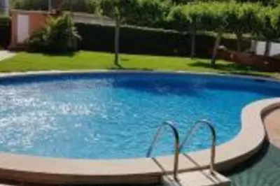 a large blue swimming pool in a yard at Lovely Sea view Apartment in Gava in Gavà