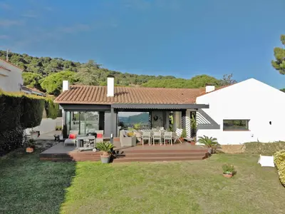 a house with a deck with tables and chairs at Premium Habitat La Plana in Argentona
