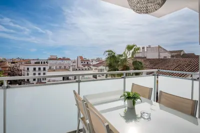 a balcony with a table and chairs and a view of the city at Sitges Spaces Oasis Penthouse 3 Bedroom, 2 Bathroom, Terrace, Pool, Sleeps up to 6 in Sitges