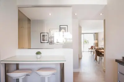 a kitchen and dining room with a counter and stools at Sitges Spaces Oasis Penthouse 3 Bedroom, 2 Bathroom, Terrace, Pool, Sleeps up to 6 in Sitges