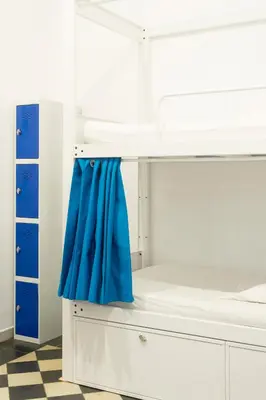 a bedroom with a bunk bed with blue curtains at Soul Backpackers Barcelona in Barcelona