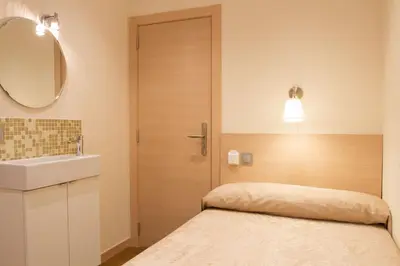 a bathroom with a bed and a sink and a mirror at Hostal Excellence in Barcelona