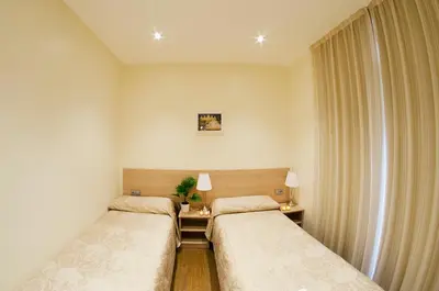 a room with two beds and a window at Hostal Excellence in Barcelona