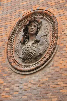 a statue of a woman on the side of a brick building at Hostal Excellence in Barcelona