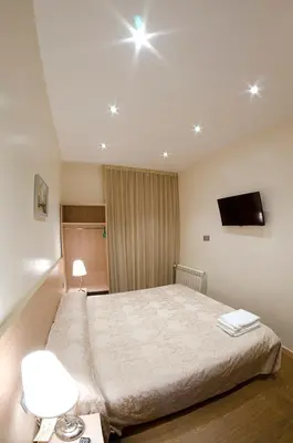 a bedroom with a bed and a tv on the ceiling at Hostal Excellence in Barcelona