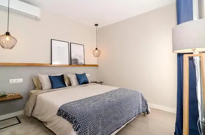 a bedroom with a large bed with blue pillows at Sitges Spaces Deluxe Centre Apartment in Sitges