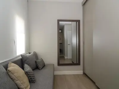 a living room with a couch and a mirror at Sitges Spaces Deluxe Centre Apartment in Sitges