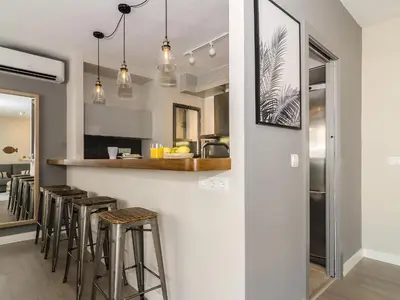 a kitchen with a bar with stools at Sitges Spaces Deluxe Centre Apartment in Sitges