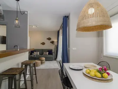 a kitchen and living room with a table and chairs at Sitges Spaces Deluxe Centre Apartment in Sitges