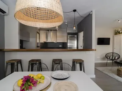 a kitchen with a table with a bowl of fruit on it at Sitges Spaces Deluxe Centre Apartment in Sitges
