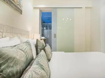 a bedroom with a white bed with green pillows at Sitges Spaces Mediterranean Apartments 4 Bedroom in Sitges