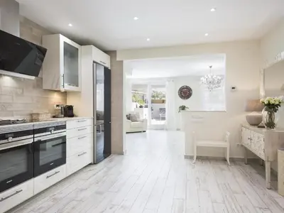 a kitchen with white cabinets and a white floor at Sitges Spaces Mediterranean Apartments 4 Bedroom in Sitges